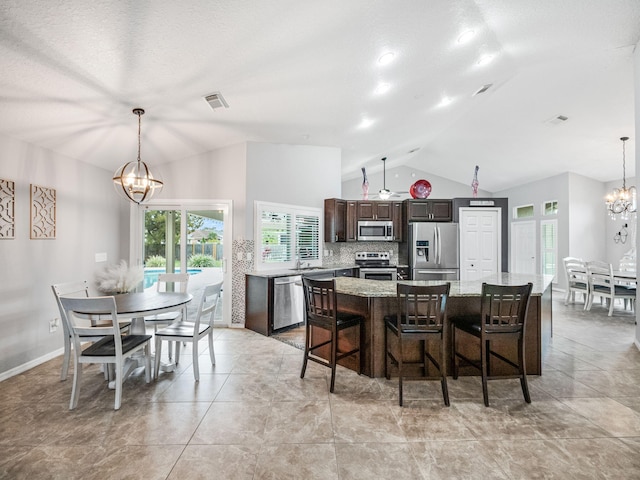 dining space with sink, vaulted ceiling, light tile patterned flooring, and a chandelier