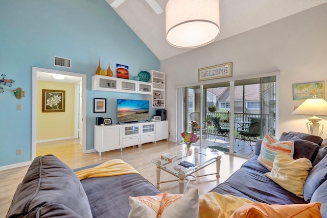 living room with light hardwood / wood-style floors and high vaulted ceiling