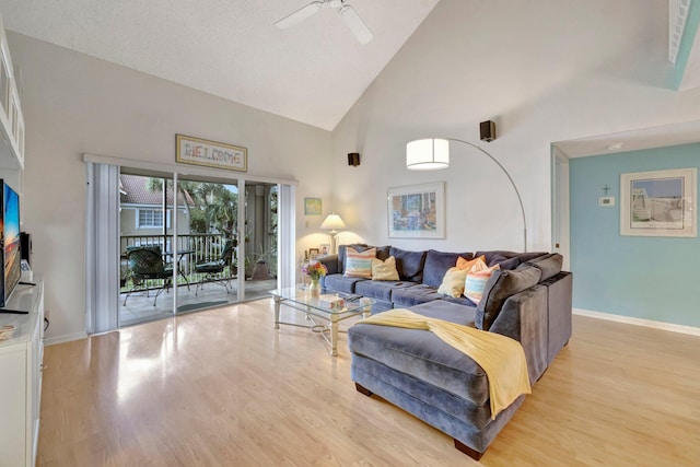 living room with ceiling fan, high vaulted ceiling, and light hardwood / wood-style floors