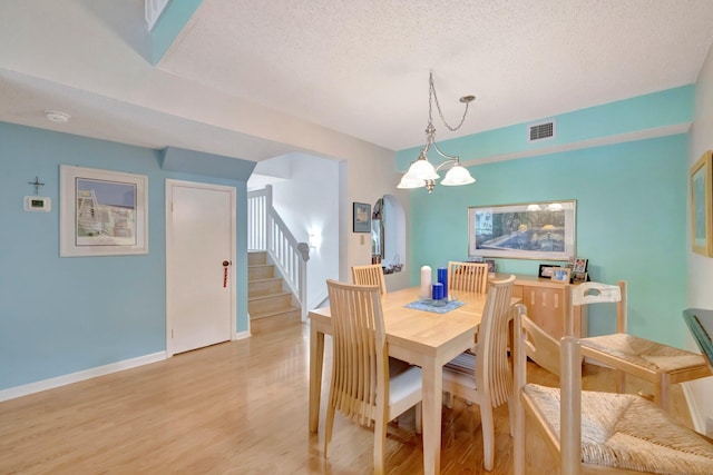 living room featuring ceiling fan, light wood-type flooring, and a high ceiling