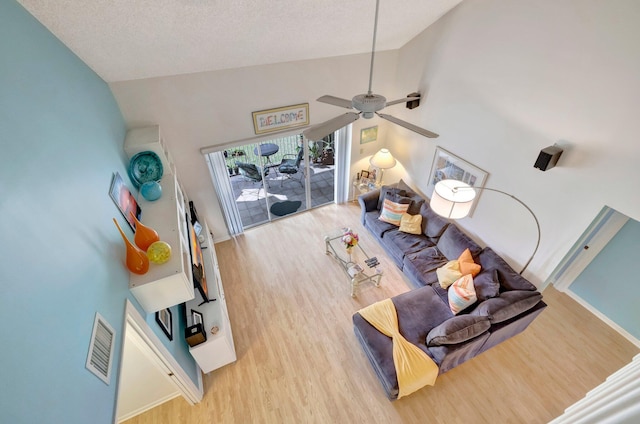 living room with ceiling fan, high vaulted ceiling, and light hardwood / wood-style flooring