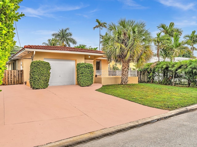 mediterranean / spanish house featuring a front yard and a garage