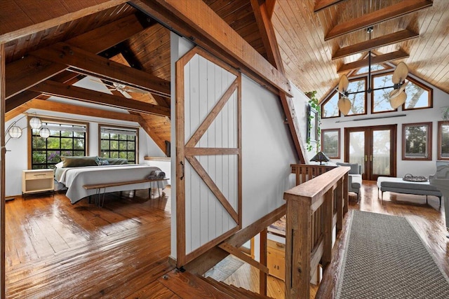 bedroom featuring lofted ceiling with beams, french doors, wood-type flooring, and wooden ceiling