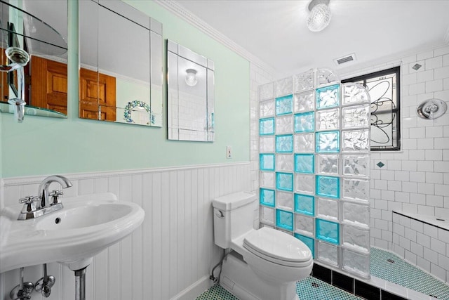 bathroom with visible vents, crown molding, walk in shower, toilet, and wainscoting