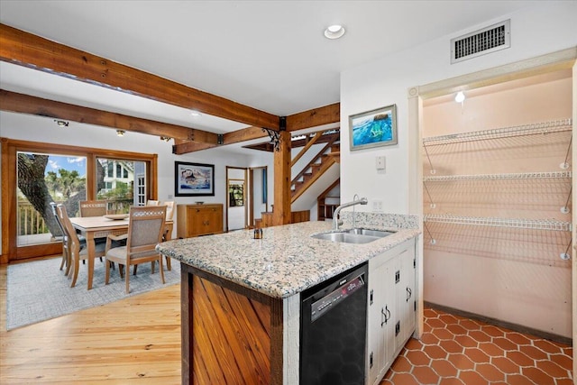 kitchen featuring visible vents, beamed ceiling, dishwasher, white cabinets, and a sink