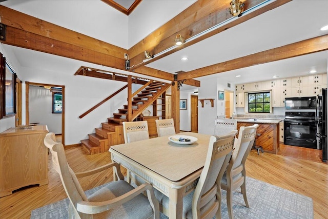 dining room featuring beam ceiling, stairway, recessed lighting, and light wood-style flooring