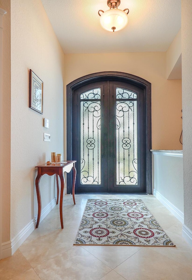 entrance foyer featuring light tile patterned floors and french doors