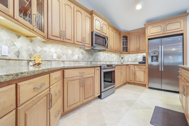 kitchen with light tile patterned flooring, appliances with stainless steel finishes, decorative backsplash, and light stone countertops