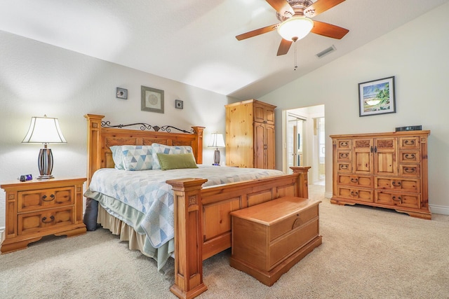 carpeted bedroom with ceiling fan, ensuite bathroom, and vaulted ceiling