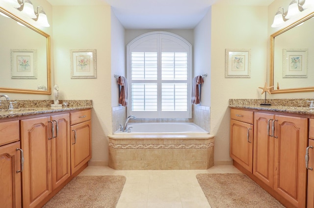 bathroom featuring vanity, tile patterned floors, and tiled tub