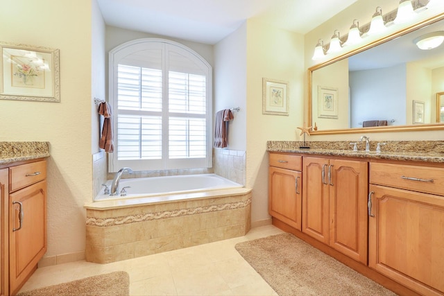 bathroom with tiled bath, tile patterned floors, and vanity