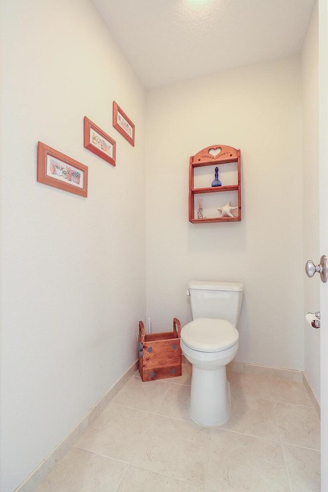 bathroom with toilet and tile patterned flooring