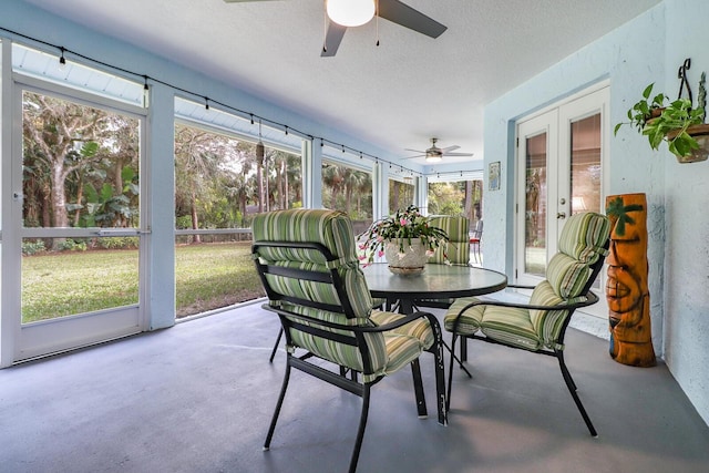 sunroom / solarium with ceiling fan, a wealth of natural light, and french doors