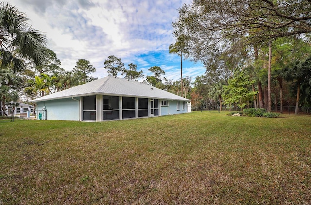 back of property featuring a yard and a sunroom