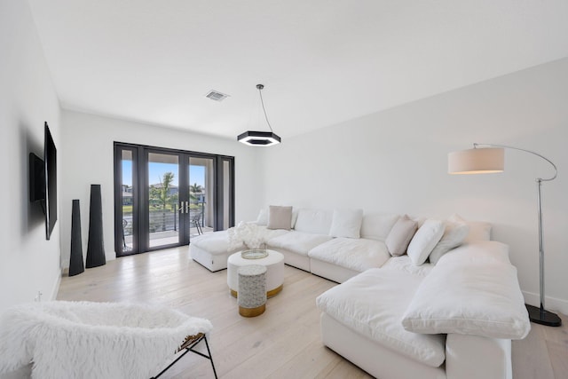 living room featuring light hardwood / wood-style flooring and french doors