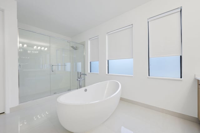 bathroom with tile patterned flooring, vanity, and shower with separate bathtub