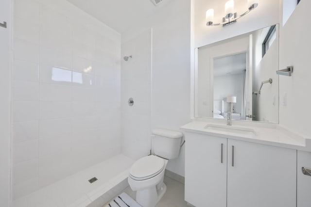 bathroom featuring vanity, toilet, and a tile shower