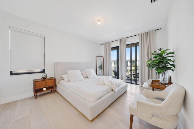 bedroom featuring access to exterior and light hardwood / wood-style flooring