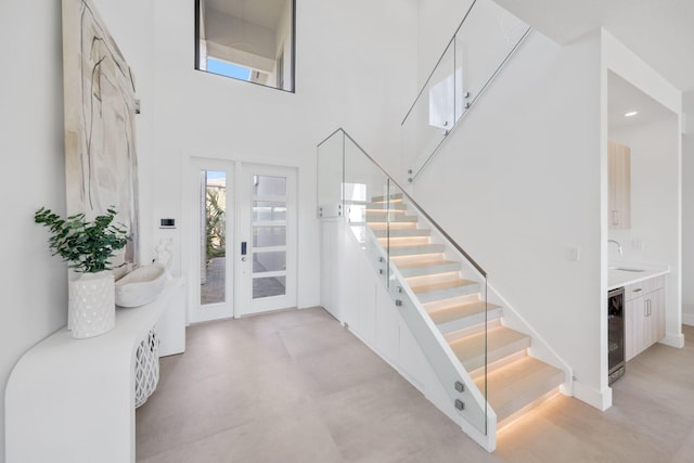 entryway featuring a towering ceiling, sink, and wine cooler