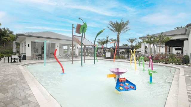 view of play area featuring pool water feature, a patio area, and a community pool