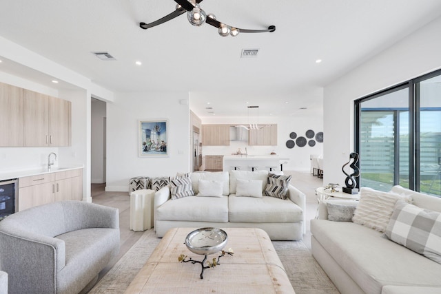 living room with ceiling fan, a wealth of natural light, and sink