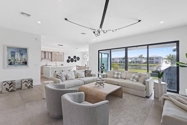 living room featuring a water view and sink