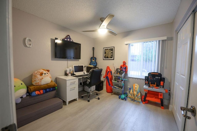 office with a textured ceiling, ceiling fan, and light hardwood / wood-style flooring