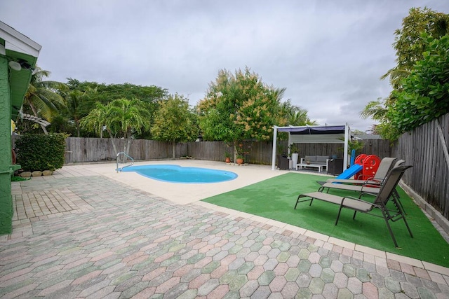 view of swimming pool with a patio area and a playground