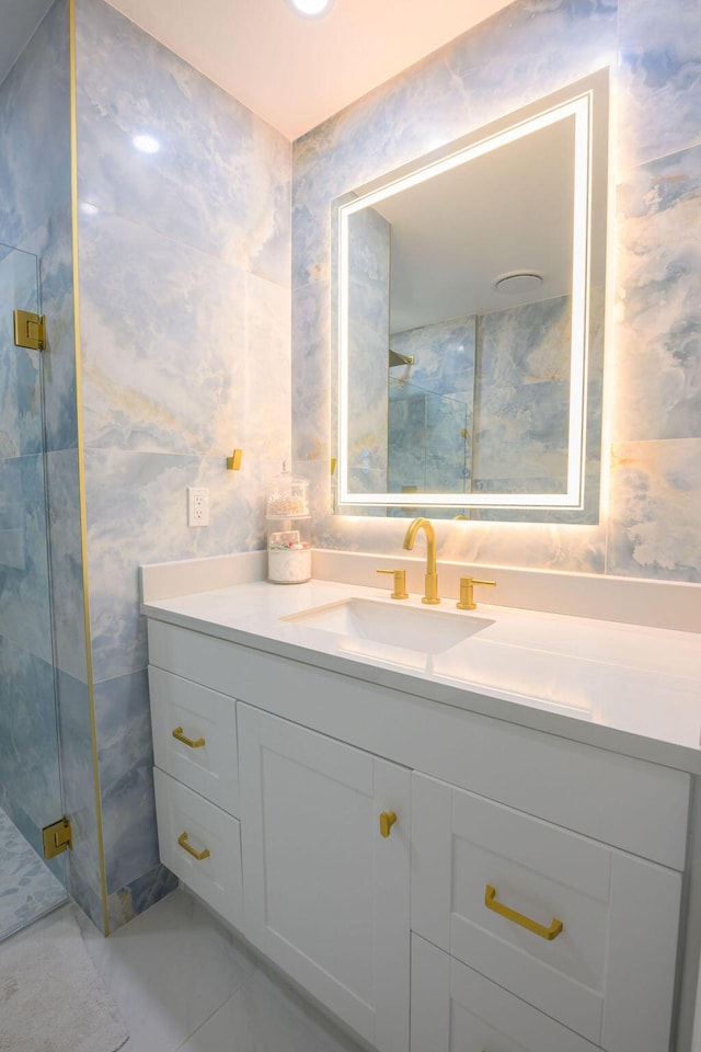 bathroom featuring a shower with door and vanity