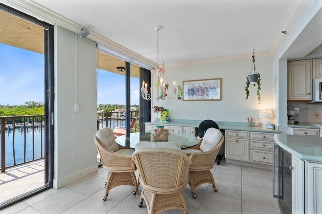 dining area featuring crown molding, light tile patterned floors, a notable chandelier, and a water view