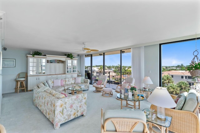 living room with light colored carpet, ceiling fan, and a wall of windows