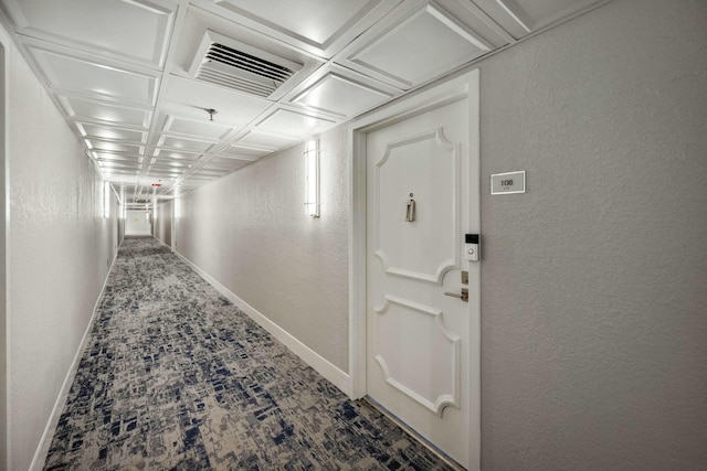 hall with carpet floors and coffered ceiling