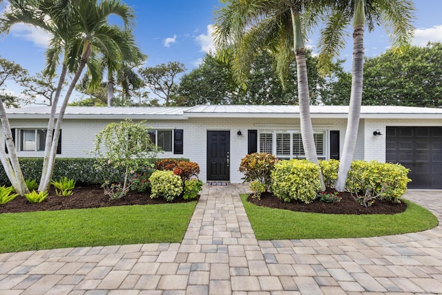 single story home with a front yard and a garage