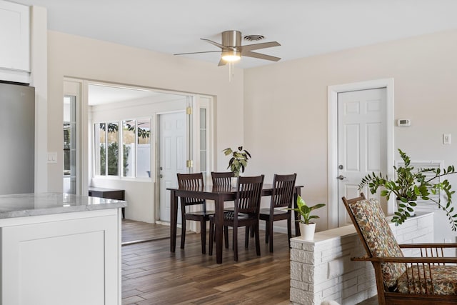 dining room with ceiling fan and dark wood-type flooring