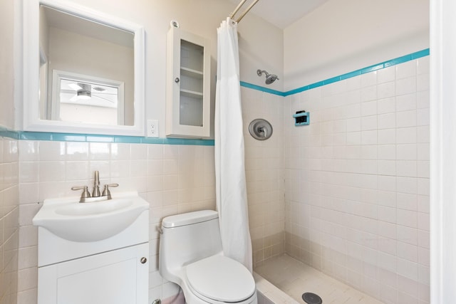 bathroom featuring walk in shower, vanity, tile walls, and toilet