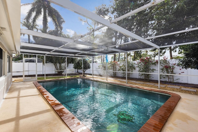 view of pool with glass enclosure and a patio area