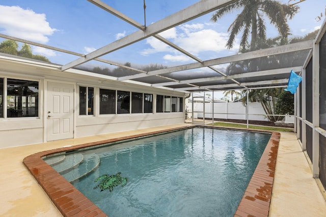 view of swimming pool featuring glass enclosure and a patio