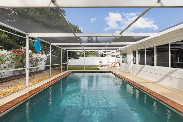 view of swimming pool featuring glass enclosure and a patio area