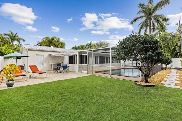 back of property with a lawn, a patio area, a lanai, and a fenced in pool