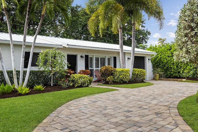 single story home with a garage and a front yard