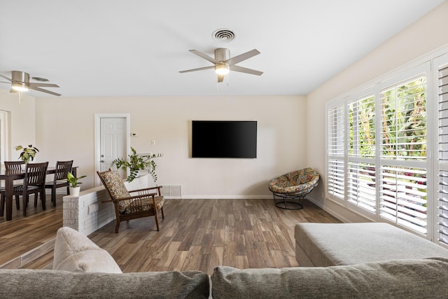 living room with ceiling fan and dark hardwood / wood-style flooring