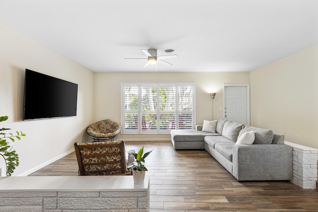 living room featuring ceiling fan and dark wood-type flooring