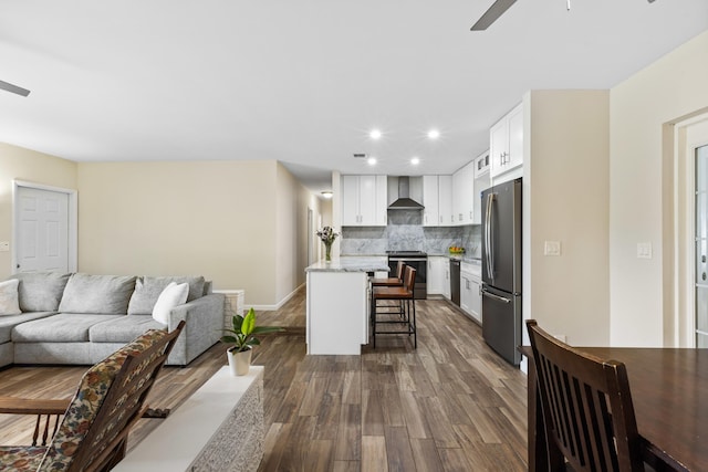 living room featuring ceiling fan and dark hardwood / wood-style floors