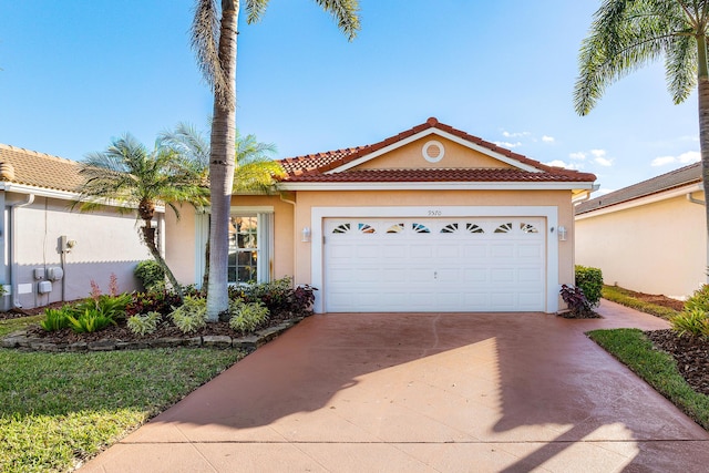 view of front of property with concrete driveway, a tiled roof, a garage, and stucco siding