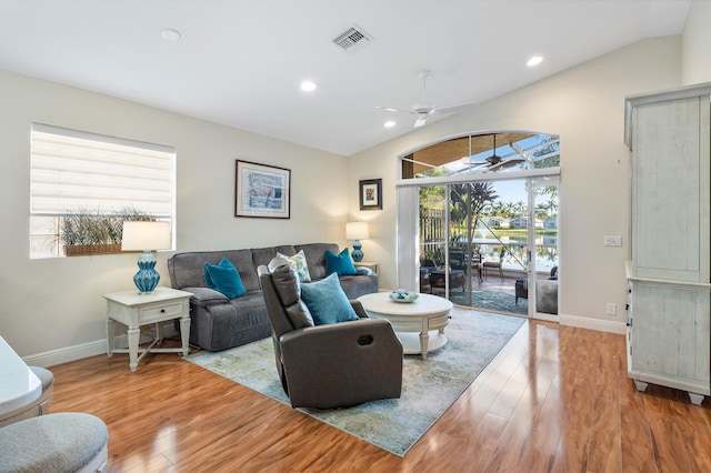 living room with ceiling fan, plenty of natural light, light hardwood / wood-style floors, and lofted ceiling