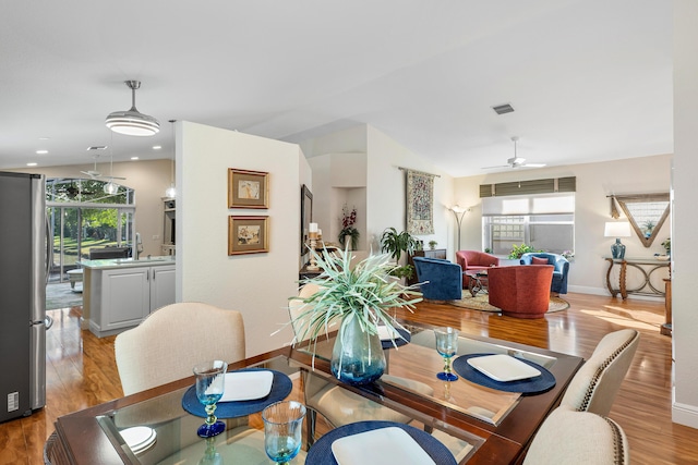 dining area featuring light wood finished floors, visible vents, and ceiling fan