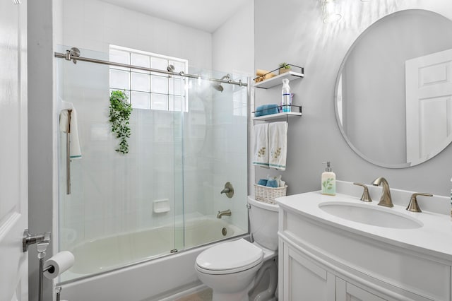 full bath featuring vanity, toilet, and shower / bath combination with glass door