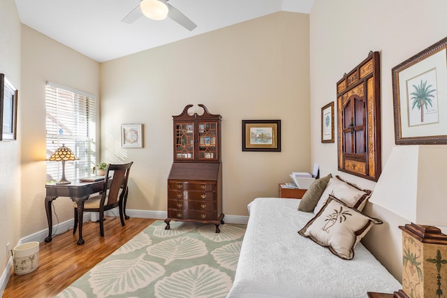 bedroom with vaulted ceiling, a ceiling fan, baseboards, and wood finished floors