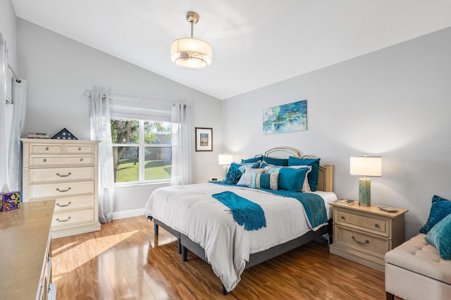 bedroom featuring light hardwood / wood-style flooring and lofted ceiling