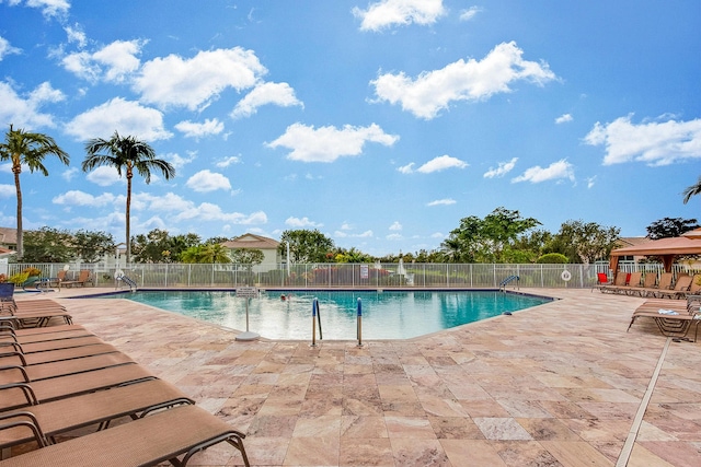 community pool featuring a patio area and fence